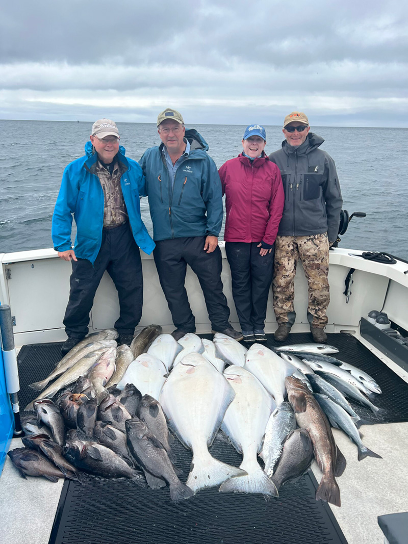 Four fishers stand behind their large catch.